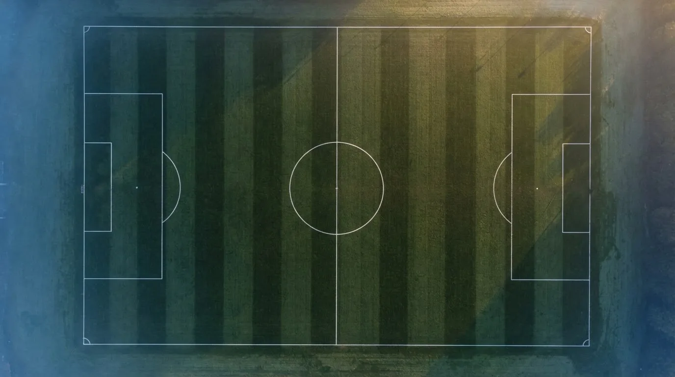 Ein Fussballplatz von oben gesehen, die Linien bilden ein helles Muster auf dem Rasen, Drohnenperspektive in der Morgendämmerung.